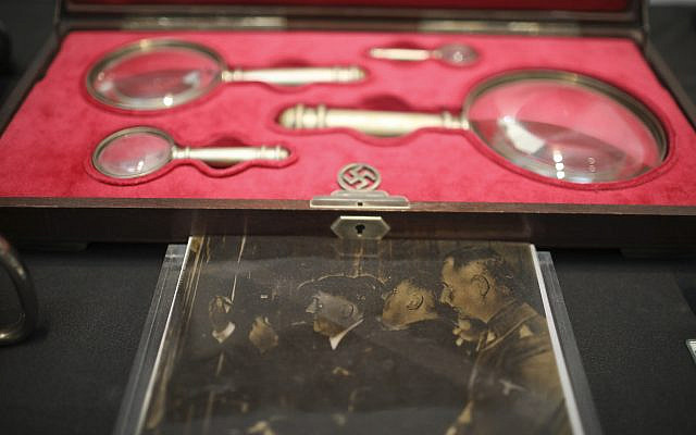 A photo of Nazi leader Adolf Hitler holding a magnifying glass is displayed during a press conference in Buenos Aires, Argentina, October 2, 2019. (Natacha Pisarenko/AP)