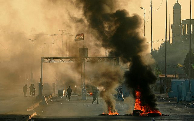 Iraqi security forces fire tear gas to disperse anti-government protesters who set fires and close a street during a demonstration in Baghdad, Iraq, Saturday, Oct. 5, 2019. The spontaneous protests which started Tuesday in Baghdad and southern cities were sparked by endemic corruption and lack of jobs. Security forces responded with a harsh crackdown, with dozens killed. (AP Photo/Hadi Mizban) Iraqi security forces fire tear gas to disperse anti-government protesters who set fires and close a street during a demonstration in Baghdad, Iraq, Saturday, Oct. 5, 2019. The spontaneous protests which started Tuesday in Baghdad and southern cities were sparked by endemic corruption and lack of jobs. Security forces responded with a harsh crackdown, with dozens killed. (AP Photo/Hadi Mizban)