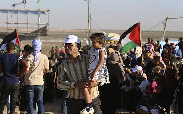 In this Sept. 25, 2019 photo, Palestinian activist Ahmed Abu Artima holds his daughter during an alternative protest he organized near the separation fence between the Gaza Strip and Israel, east of Gaza City. (AP Photo/Adel Hana) In this Sept. 25, 2019 photo, Palestinian activist Ahmed Abu Artima holds his daughter during an alternative protest he organized near the separation fence between the Gaza Strip and Israel, east of Gaza City. (AP Photo/Adel Hana)
