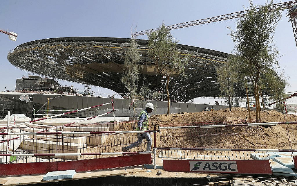 In this Oct. 8, 2019, photo, a worker passes in front of the Sustainability Pavilion at the under construction site of the Expo 2020 in Dubai, United Arab Emirates. (AP Photo/Kamran Jebreili)