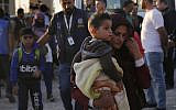A Syrian woman who is newly displaced by the Turkish military operation in northeastern Syria, carries her son upon her arrival at the Bardarash camp, north of Mosul, Iraq, October 16, 2019. (AP Photo/Hussein Malla)