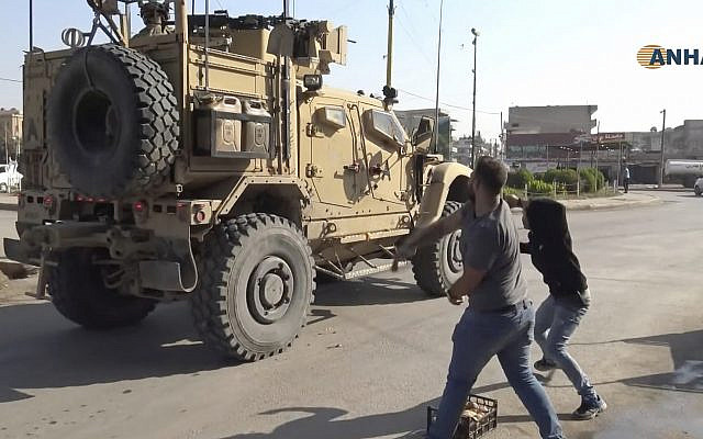 In this frame grab from video provided by Hawar News, ANHA, the Kurdish news agency, residents who are angry over the US withdrawal from Syria hurl potatoes at American military vehicles in the town of Qamishli, northern Syria, October 21, 2019. (ANHA via AP) In this frame grab from video provided by Hawar News, ANHA, the Kurdish news agency, residents who are angry over the US withdrawal from Syria hurl potatoes at American military vehicles in the town of Qamishli, northern Syria, October 21, 2019. (ANHA via AP)