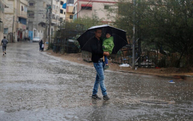 A Palestinian man holds a child under an umbrella during rainfall in Gaza City, October 26, 2019. (AP Photo/ Hatem Moussa) A Palestinian man holds a child under an umbrella during rainfall in Gaza City, October 26, 2019. (AP Photo/ Hatem Moussa)