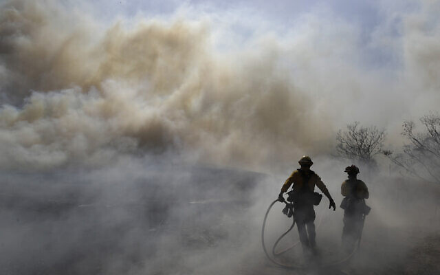Firefighters walk through a cloud of smoke as winds fuel the Easy Fire Wednesday, Oct. 30, 2019, in Simi Valley, Calif. Fire officials say they're investigating the cause of the fire. (AP Photo/Marcio Jose Sanchez) Firefighters walk through a cloud of smoke as winds fuel the Easy Fire Wednesday, Oct. 30, 2019, in Simi Valley, Calif. Fire officials say they're investigating the cause of the fire. (AP Photo/Marcio Jose Sanchez)