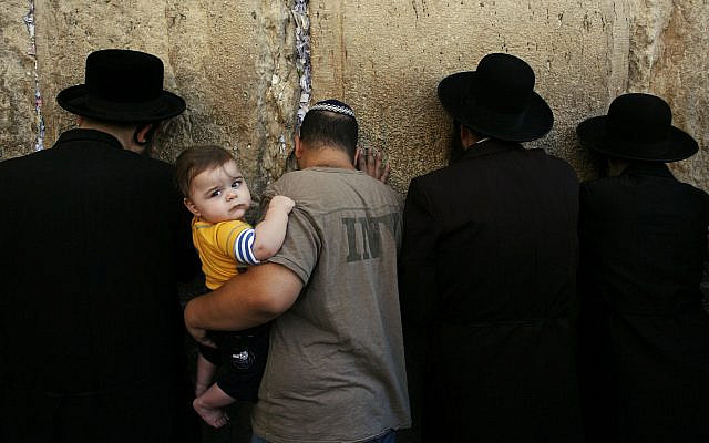 A Jewish man holds a child as he participates in morning prayers before the beginning of the Jewish holiday of Yom Kippur, at the Western Wall, Judaism's holiest site in Jerusalem's Old City, Wednesday, Oct. 8, 2008. (AP Photo/Kevin Frayer) A Jewish man holds a child as he participates in morning prayers before the beginning of the Jewish holiday of Yom Kippur, at the Western Wall, Judaism's holiest site in Jerusalem's Old City, Wednesday, Oct. 8, 2008. (AP Photo/Kevin Frayer)