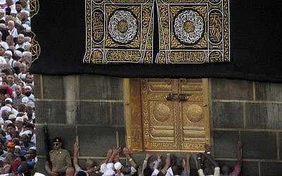 Muslim pilgrims touch the golden door of the Kaaba, the cubic building at the Grand Mosque, during the hajj pilgrimage in the Muslim holy city of Mecca, Saudi Arabia, August 13, 2019. (Amr Nabil/AP)