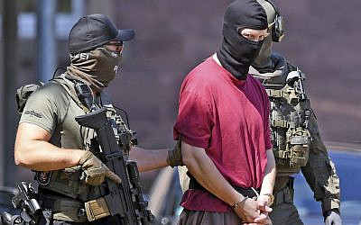 Stephan Ernst, center, is escorted to a helicopter in Karlsruhe, Germany, after being arrested for the murder of a regional politician from Chancellor Angela Merkel's party, July 2, 2019. (Uli Deck/dpa via AP)