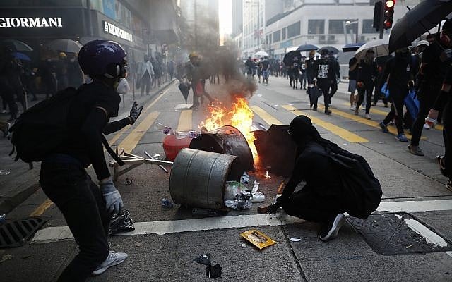 Anti-government protesters set fire to block traffic in Hong Kong, October 1, 2019. (AP Photo/Gemunu Amarasinghe ) Anti-government protesters set fire to block traffic in Hong Kong, October 1, 2019. (AP Photo/Gemunu Amarasinghe )