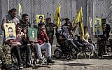 Wounded Kurdish fighters hold portraits of comrades who were killed while fighting against the Islamic State, during a demonstration against an anticipated Turkish incursion targeting Syrian Kurdish fighters, in front the United Nations building, in Qamishli, northeast Syria, Monday, Oct. 8, 2019. (AP Photo/Ahmad Baderkhan)