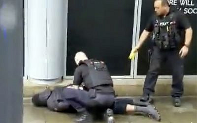 In this image taken from mobile phone footage, police arrest a man outside the Arndale Centre in Manchester, England, Friday October 11, 2019, after a stabbing incident at the shopping center that left four people injured. Greater Manchester Police say a man in his 40s has been arrested on suspicion of serious assault. He has been taken into custody. (John Greenhalgh via AP)