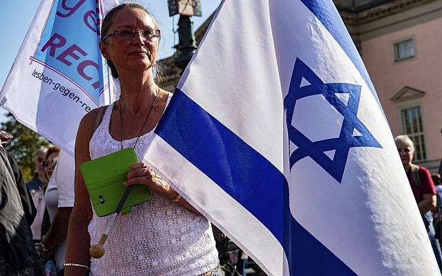 A woman with an Israeli flag protests with thousands of people on Sunday, Oct. 13, 2019 in Berlin, Germany, against rising anti-Semitism, days after a man attacked a synagogue in the eastern German city of Halle. (Paul Zinken/dpa via AP)