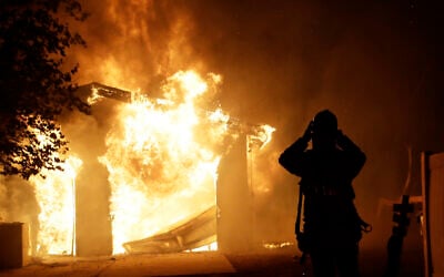 A firefighter prepares to fight a wildfire as it overtakes a home October 24, 2019, in Santa Clarita, California (AP Photo/Marcio Jose Sanchez)
