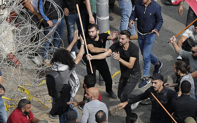 Anti-government protesters, left, and Hezbollah supporters, right, clash during a protest near the government palace, in downtown Beirut, Lebanon, October 25, 2019. (AP Photo/Hussein Malla) Anti-government protesters, left, and Hezbollah supporters, right, clash during a protest near the government palace, in downtown Beirut, Lebanon, October 25, 2019. (AP Photo/Hussein Malla)