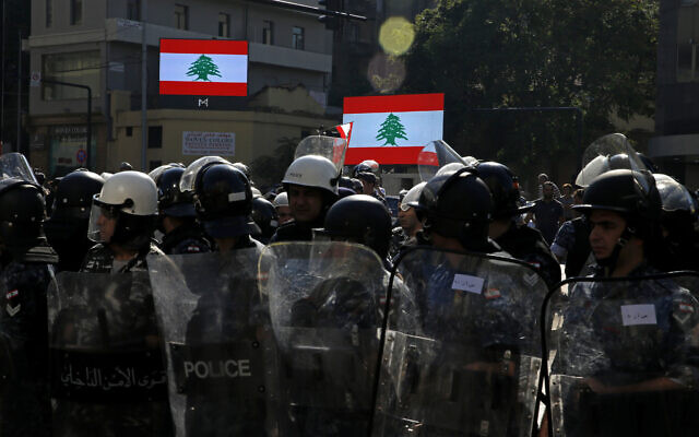 Riot police stand guard after they open a road in Beirut, Lebanon, Oct. 31, 2019 (AP Photo/Bilal Hussein)