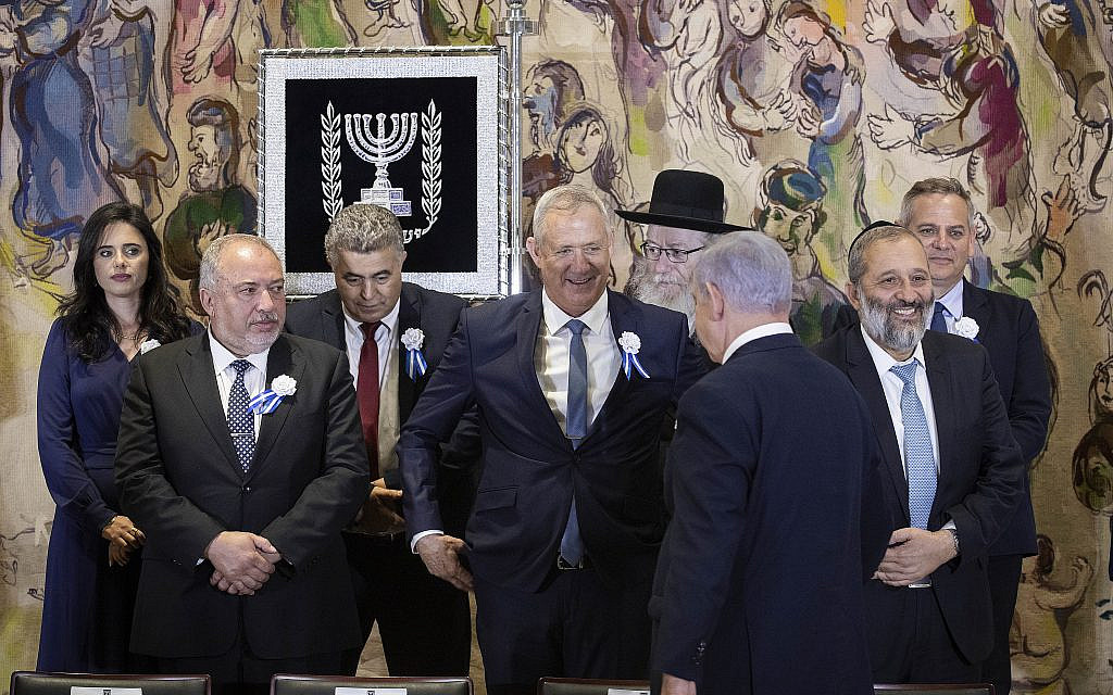 Prime Minister Benjamin Netanyahu approaches rival Benny Gantz as they and other party leaders including Avigdor Liberman and Aryeh Deri prepare to pose for a group picture during the swearing-in of the 22nd Knesset in Jerusalem, on October 3, 2019. (Hadas Parush/Flash90) Prime Minister Benjamin Netanyahu approaches rival Benny Gantz as they and other party leaders including Avigdor Liberman and Aryeh Deri prepare to pose for a group picture during the swearing-in of the 22nd Knesset in Jerusalem, on October 3, 2019. (Hadas Parush/Flash90)