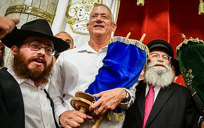 Blue and White party chairmen Benny Gantz carries a Torah scroll as he dances during Simhat Torah celebrations in Kfar Chabad, on October 21, 2019. (Yossi Zeliger/Flash90)