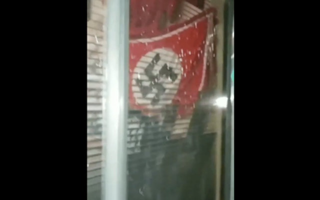 A Nazi flag seen is seen in a window of the California Department of Corrections and Rehabilitation. (Screenshot from video uploaded to Imgur by California Department of Corrections via JTA) A Nazi flag seen is seen in a window of the California Department of Corrections and Rehabilitation. (Screenshot from video uploaded to Imgur by California Department of Corrections via JTA)