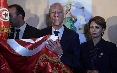 Conservative academic Kais Saied, center, flanked by his wife Ichraf Chebil, right, celebrates his victory in the Tunisian presidential election in the capital Tunis on October 13, 2019. (Fethi Belaid/AFP)
