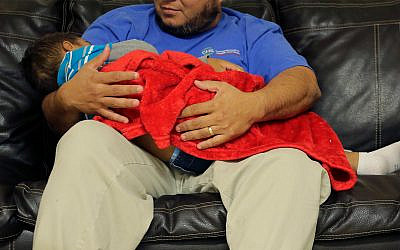 A migrant toddler is cradled by a Comprehensive Health Services, Inc. caregiver at a "tender-age" facility for babies, children and teens, in Texas's Rio Grande Valley, August 29, 2019, in San Benito, Texas. (AP Photo/Eric Gay)