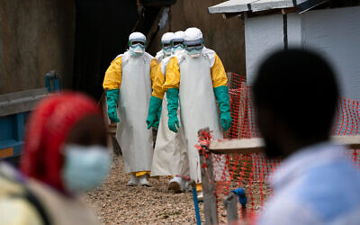 Illustrative: Health workers dressed in protective gear begin their shift at an Ebola treatment center in Beni, Congo DRC, July 16, 2019. (AP Photo/Jerome Delay)