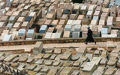 ILLUSTRATIVE -- A man walks through a cemetery in Jerusalem (Nati Shohat /Flash90)