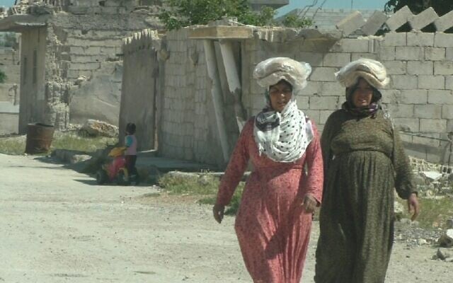 Women walk on the streets of Kobani, Syria. (Ziv Genesove/Times of Israel)