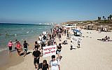 Surfers protest plans to install a breakwater at the last open beach in Tel Aviv, October 4, 2019. (eyesurf productions)