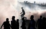 Palestinian rioters stand amid tear gas canisters fired by Israeli forces during clashes along the border with Israel east of Bureij in the central Gaza Strip on November 1, 2019. (Mahmud Hams/AFP)