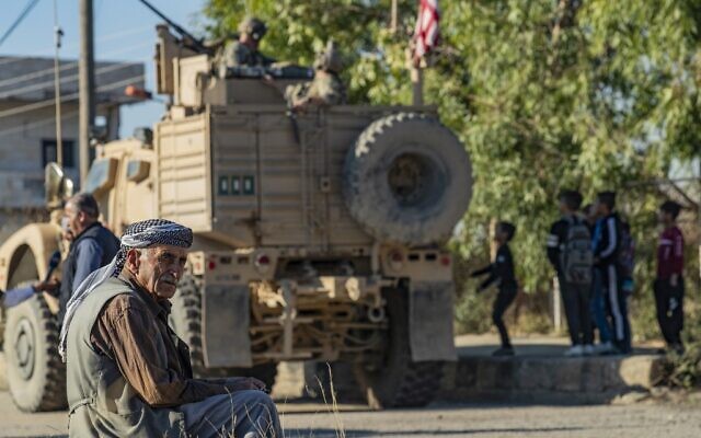 A Syrian man sits near a US armored vehicle on patrol in the village of Ein Diwar in Syria's northeastern Hasakeh province on November 4, 2019. (Delil SOULEIMAN / AFP) A Syrian man sits near a US armored vehicle on patrol in the village of Ein Diwar in Syria's northeastern Hasakeh province on November 4, 2019. (Delil SOULEIMAN / AFP)