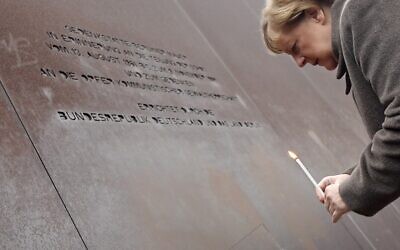 German Chancellor Angela Merkel places a candle at the Berlin Wall Memorial during the central commemoration ceremony for the 30th anniversary of the fall of the Berlin Wall, on November 9, 2019 (Tobias SCHWARZ / AFP)