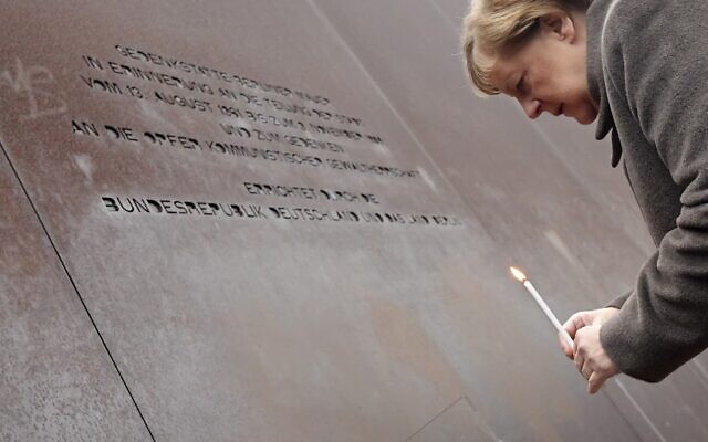 German Chancellor Angela Merkel places a candle at the Berlin Wall Memorial during the central commemoration ceremony for the 30th anniversary of the fall of the Berlin Wall, on November 9, 2019 (Tobias SCHWARZ / AFP)