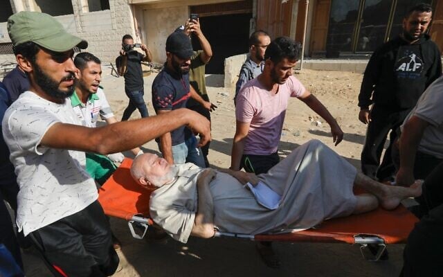Palestinian evacuate a wounded man in Gaza City on November 12, 2019, after an Israeli airstrike killed a commander of the Palestinian Islamic Jihad terror group. (MAHMUD HAMS / AFP)