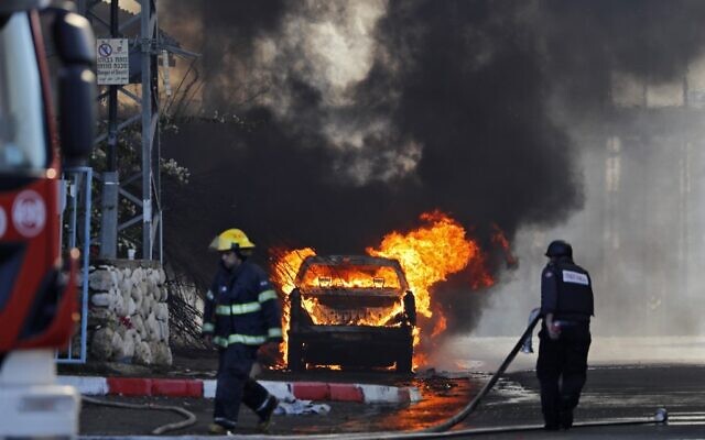 A vehicle parked in front of a factory that was hit with a rocket fired from the Gaza Strip catches fire in the southern town of Sderot on November 12, 2019. (Ahmad Gharabli/AFP) A vehicle parked in front of a factory that was hit with a rocket fired from the Gaza Strip catches fire in the southern town of Sderot on November 12, 2019. (Ahmad Gharabli/AFP)
