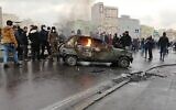 Illustrative: Iranian protesters gather around a burning car during a demonstration against an increase of gasoline prices, in the capital Tehran, November 16, 2019. (AFP)