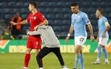 A man runs onto the field and hugs Poland's forward Robert Lewandowski on the pitch during the EURO 2020 group G qualifiers football match between Israel and Poland at the Teddy stadium in Jerusalem on November 16, 2019. He and a second invading fan were taken away by security guards. (Photo by Jack GUEZ / AFP)