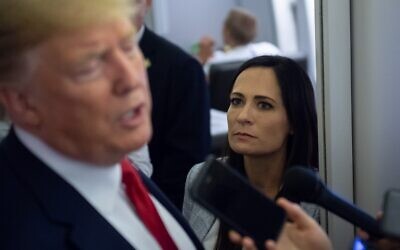 In this file photo taken on August 8, 2019, White House Press Secretary Stephanie Grisham listens as US President Donald Trump speaks to the media aboard Air Force One while flying between El Paso, Texas and Joint Base Andrews in Maryland. (Photo by SAUL LOEB / AFP)