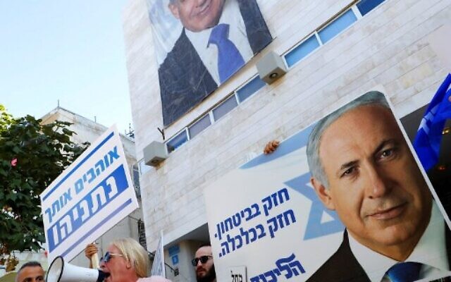 Supporters of then-prime minister Benjamin Netanyahu chant slogans and hold up signs in support of him, during a counterrally outside the Likud party headquarters in Tel Aviv, on November 22, 2019, as Labor Party supporters demonstrate against him nearby. (Jack Guez/AFP) Supporters of then-prime minister Benjamin Netanyahu chant slogans and hold up signs in support of him, during a counterrally outside the Likud party headquarters in Tel Aviv, on November 22, 2019, as Labor Party supporters demonstrate against him nearby. (Jack Guez/AFP)