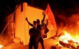 Iraqi demonstrators gesture as flames start consuming Iran's consulate in the southern Iraqi Shiite holy city of Najaf on November 27, 2019, two months into the country's most serious social crisis in decades. (AFP)