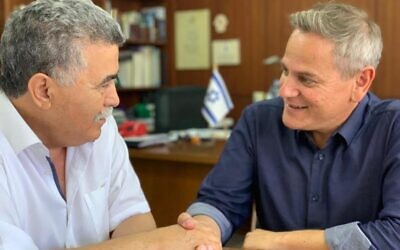 Labor chairman Amir Peretz (L) shakes hands with Meretz (and later Democratic Camp) chairman Nitzan Horowitz on July 17, 2019. (Courtesy)