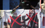 A poster of Iraq Parliament Speaker Mohammed al-Halbousi, right, and Iran President Hassan Rouhani, left, hang on a building near Tahrir Square, during ongoing protests in Baghdad, Iraq, November 6, 2019. (AP Photo/Hadi Mizban)
