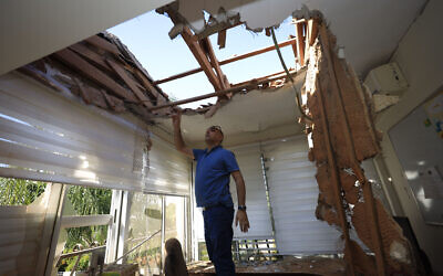 A man looks at the damage to a house in Sderot, Israel, after it was hit by a rocket fired from Gaza Strip, Nov. 12, 2019. (AP Photo/Tsafrir Abayov)
