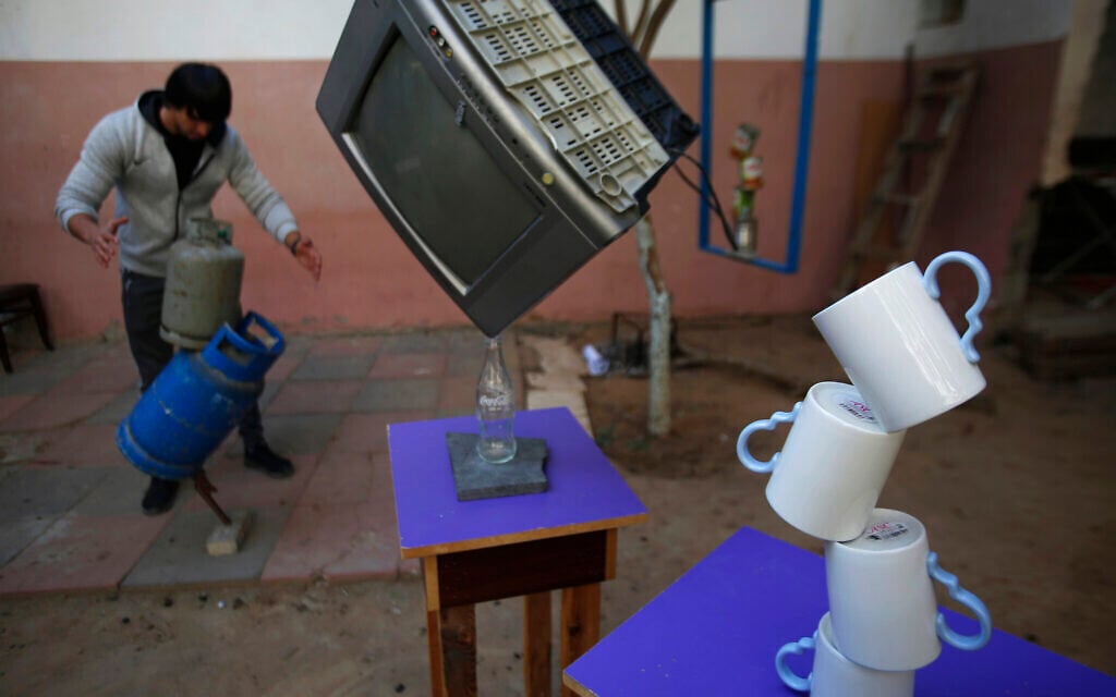 In this Nov. 20, 2019, photo, Mohammed al-Shenbari demonstrates to balance objects using what he calls a mix of mind and body, in the yard of his home in Beit Hanoun, northern Gaza Strip. (AP Photo/Hatem Moussa)