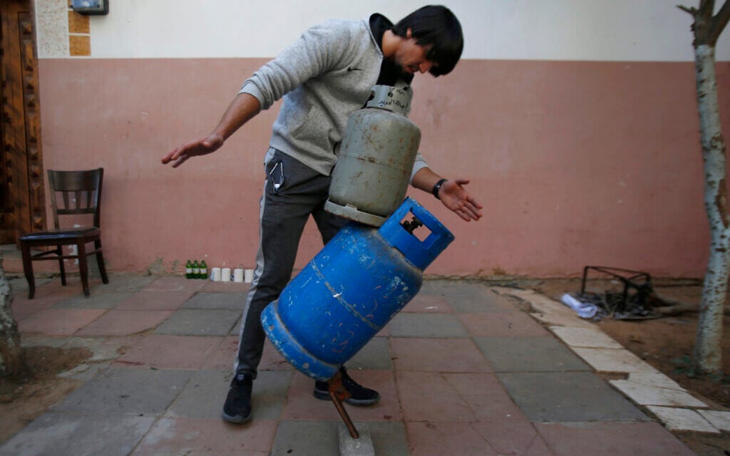 In this Nov. 20, 2019, photo, Mohammed al-Shenbari demonstrates to balance objects using what he calls a mix of mind and body, in the yard of his home in Beit Hanoun, northern Gaza Strip. (AP Photo/Hatem Moussa)