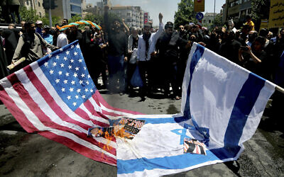 Iranian protesters burn Israeli and US flags in their annual anti-Israeli Al-Quds, Jerusalem, Day rally in Tehran, Iran, June 8, 2018. (AP/Ebrahim Noroozi)