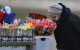 A woman smells the flowers at a street market on the eve of the International Women's Day in Minsk, Belarus on March 7, 2019. (AP Photo/Sergei Grits)