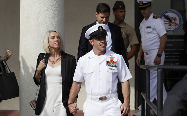 Navy Special Operations Chief Edward Gallagher, center, walks with his wife, Andrea Gallagher, as they leave a military court on Naval Base San Diego, Tuesday, July 2, 2019, in San Diego. A military jury acquitted the decorated Navy SEAL Tuesday of murder in the killing of a wounded Islamic State captive under his care in Iraq in 2017. (AP Photo/Gregory Bull)