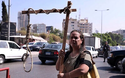 A former inmate of Khiam prison holds a mock gallows during a sit-in near a military court where an arrest warrant was issued for Lebanese-American Amer Fakhoury, who confessed he'd worked for Israel during its occupation of Lebanon for nearly two decades, in Beirut, Lebanon, Tuesday, September 17, 2019. (AP Photo/Bilal Hussein)