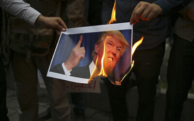 In this May 9, 2018, file photo, Iranian demonstrators burn a picture of US President Donald Trump during a protest in front of the former US Embassy in Tehran, Iran. (AP Photo/Vahid Salemi, File)
