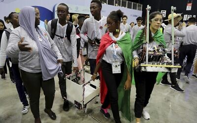 In this Friday, Oct. 25, 2019 photo, different team members carry their robots during the First Global Challenge, a robotics and artificial intelligence competition in Dubai, United Arab Emirates.  (AP Photo/Kamran Jebreili)