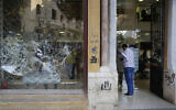 A client enters a bank with a front window shattered during anti-government protests in Beirut, Lebanon, Nov. 1, 2019. (AP Photo/Hussein Malla)
